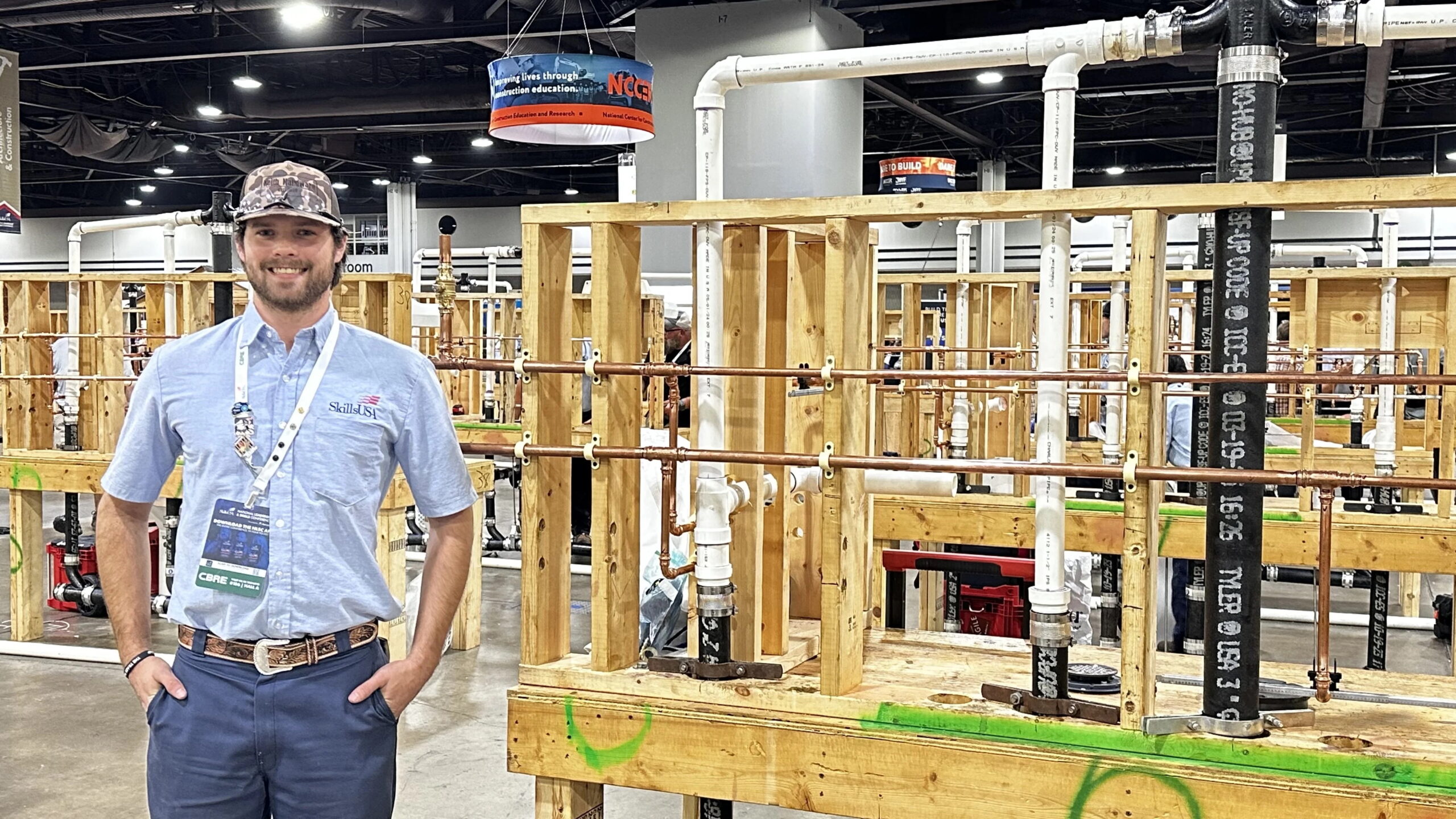 TSTC Student Jonathan Gann stands on the SkillsUSA competition floor wearing his gold medal.